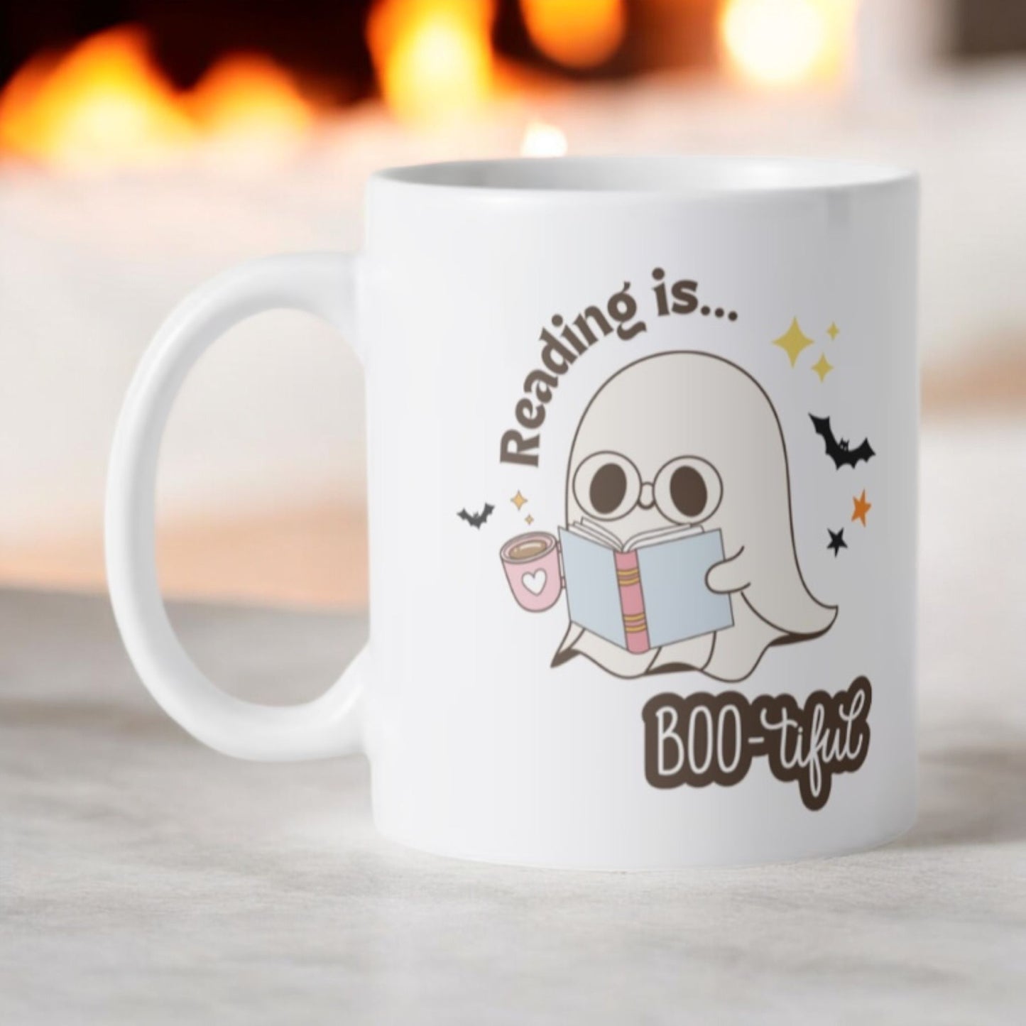 Keramische witte beker met een afbeelding van spookje dat leest en de tekst “ Reading is bootiful” Halloween cadeau