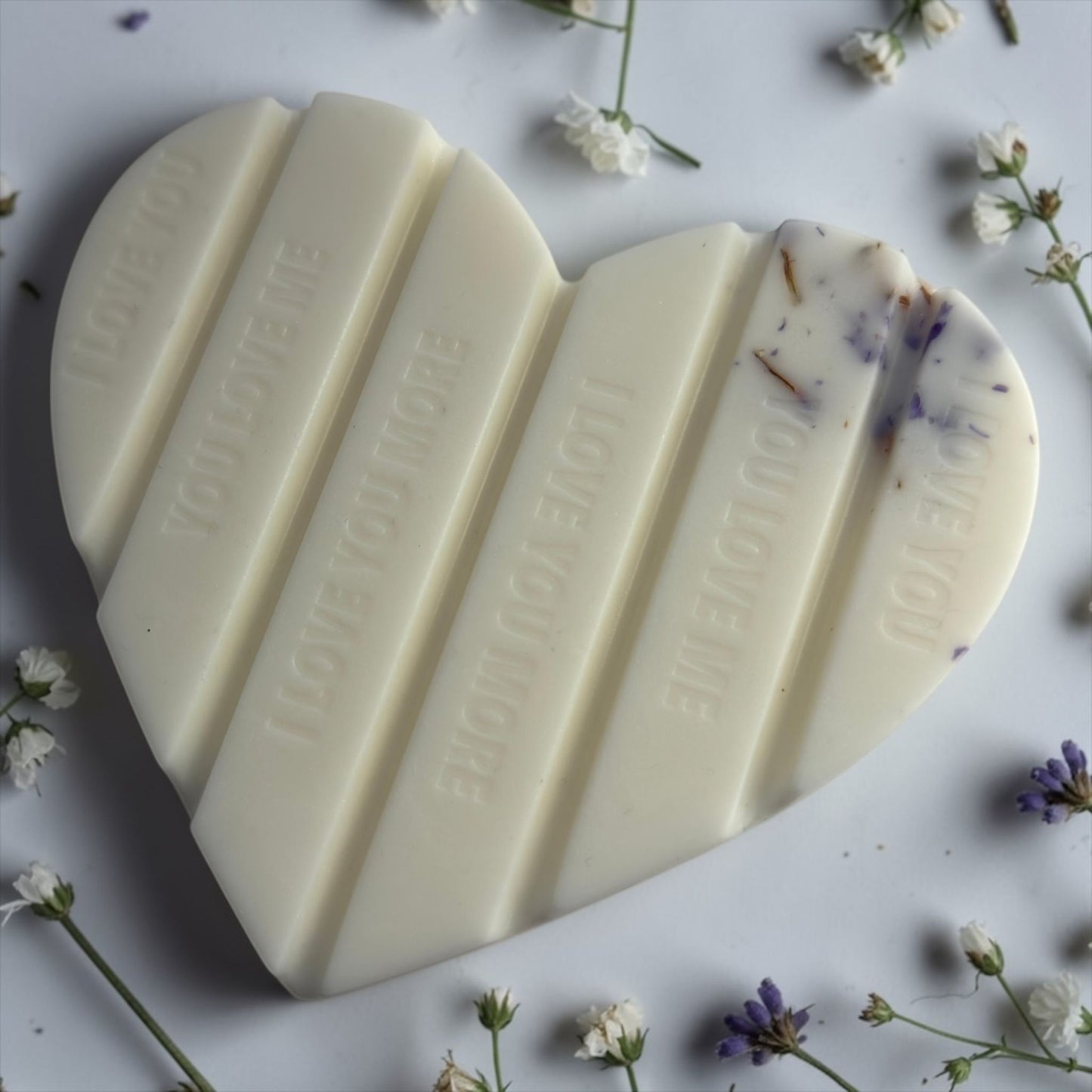 Handgemaakte witte hartvormige waxmelt 'Heavenly White Musk' van Macey's Candles in een kraft doosje. De was bevat paarde bloemblaadjes en glitters.