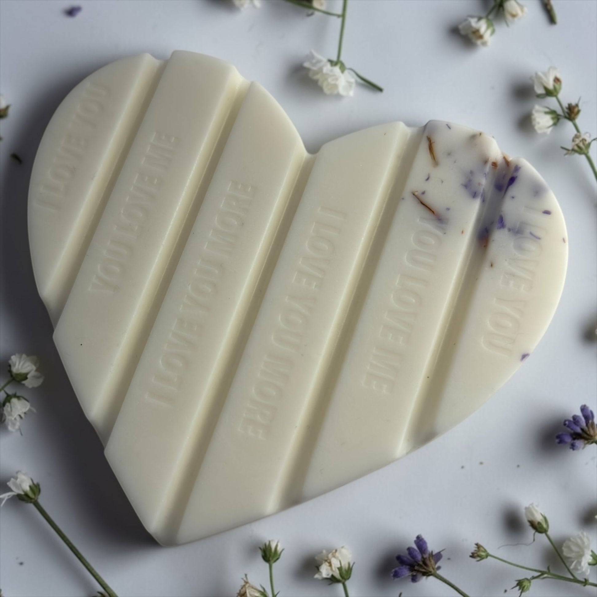 Handgemaakte witte hartvormige waxmelt 'Heavenly White Musk' van Macey's Candles in een kraft doosje. De was bevat paarde bloemblaadjes en glitters.