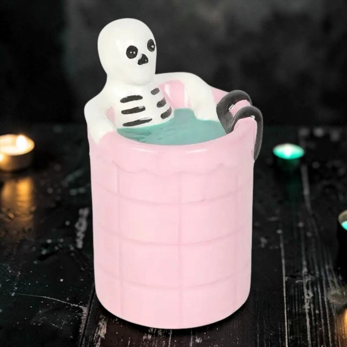 Keramische waxbrander Dead Cool met een skelet zittend in een roze getegeld badje op een zwarte achtergrond⁠