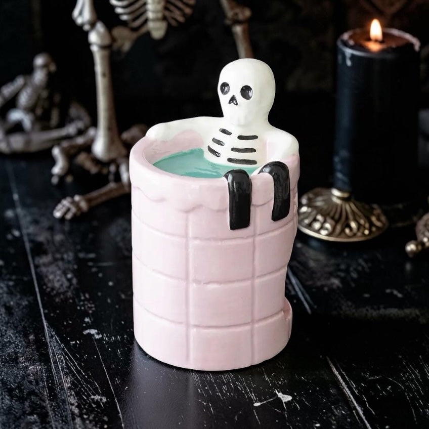 Keramische waxbrander Dead Cool met een skelet zittend in een roze getegeld badje op een zwarte achtergrond⁠